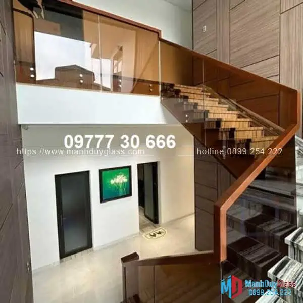 Cầu thang kính màu trà và tay vịn gỗ